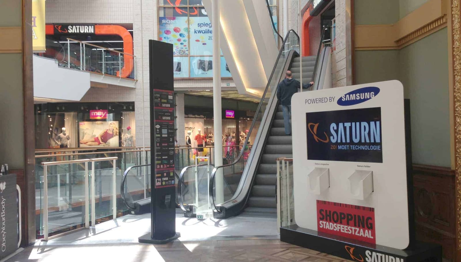 A digital totem at the foot of the escalator in the Stadsfeestzaal shopping centre in Antwerp, running store content on easyCMS